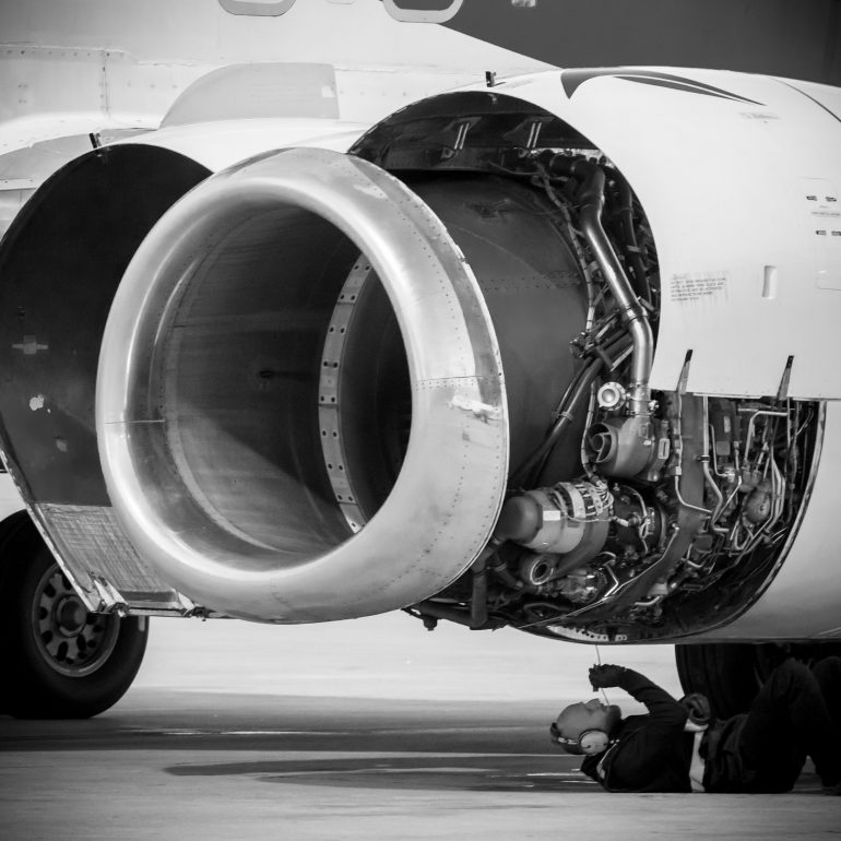 man-working-on-aircraft-engine